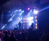 Imagen ilustrativa. Escenario de concierto de música country con luces ambientales.