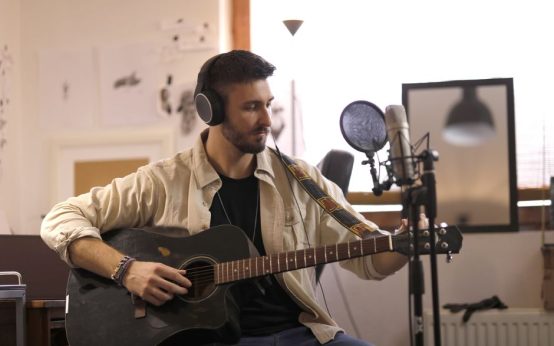 Guitarra acústica y micrófono en un estudio de grabación