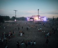 Escenario de festival al aire libre preparado para un concierto nocturno