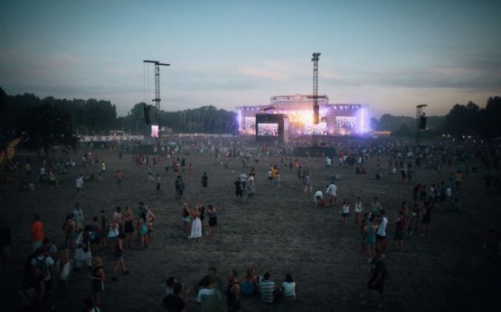 Escenario de festival al aire libre preparado para un concierto nocturno