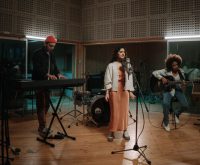 Estudio de grabación con guitarra acústica y micrófono vintage, evocando la atmósfera del folk rock