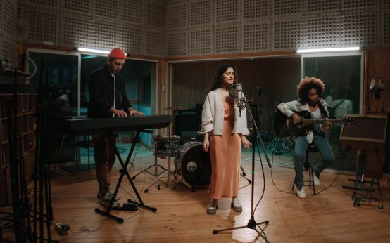 Estudio de grabación con guitarra acústica y micrófono vintage, evocando la atmósfera del folk rock